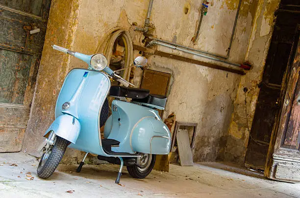 Photo of Blue vintage moped in an old garage