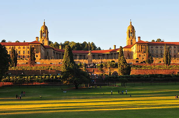 Union Buildings, Pretoria at Sunset "South African Union Buildings seen here at sundown. The Union Buildings were built from light sandstone and designed by the Sir Herbert Baker in the English monumental style. The Buildings are over 275 m long and a semi-circular shape, with the two wings at the sides that represent the union of a formerly divided people. (English and Afrikaans). The Union Buildings are considered by many to be the architect's greatest achievement and a South African architectural masterpiece. The cornerstone was laid in November 1910. Requiring over 1,265 workers over 3 years to build, the structure was completed in 1913. Today, the official seat of the South African government and also the offices of the President of South Africa." union buildings stock pictures, royalty-free photos & images