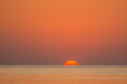 amazing red sun with orange sky and sea on vacation in egypt