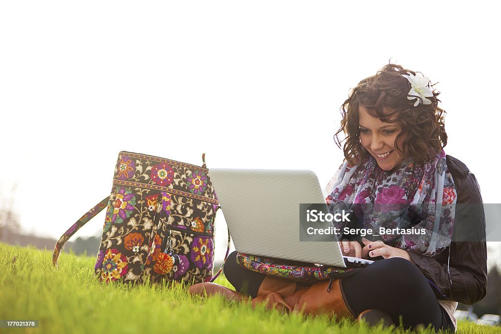 Bonito jovem estudante usando o laptop na grama - Foto de stock de Adolescência royalty-free