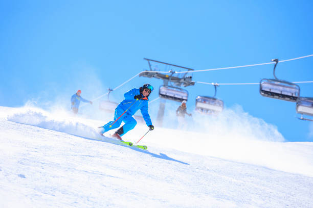 aktiver lebensstil, vital senior herren schneeskifahrer, skifahren, genießen in sonnigen skigebieten. skicarven mit hoher geschwindigkeit vor blauem himmel. - skiing point of view stock-fotos und bilder