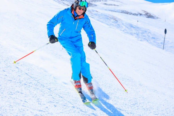 stile di vita attivo, vital senior uomo sciatore sulla neve sci, godendo su stazioni sciistiche soleggiate. sci carving ad alta velocità contro il cielo blu. - skiing point of view foto e immagini stock