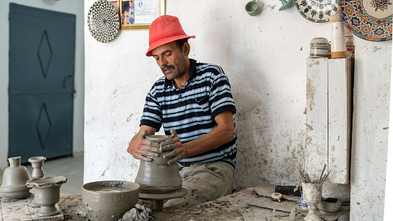 Fes, Morocco - 10 September 2022: Moroccan craftsman making pottery by hand.