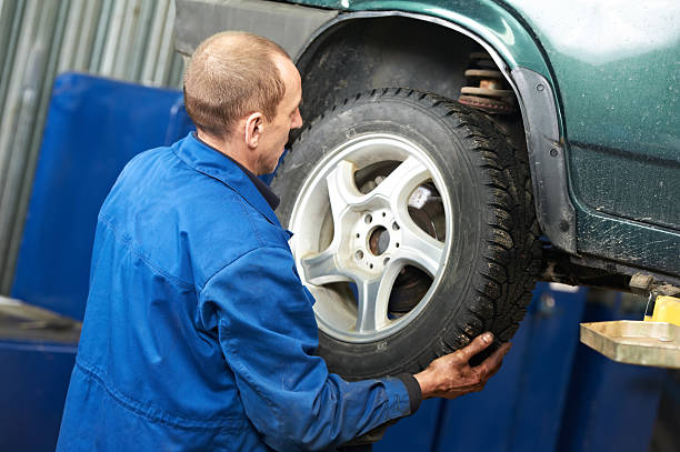 istock mechanic installing car wheel at service station 177024481