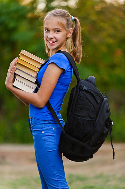 Adolescent fille tenant une pile de livres sept - Photo