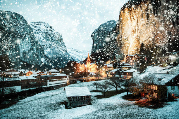 amazing touristic alpine village at night in winter with famous church and Staubbach waterfall  Lauterbrunnen  Switzerland  Europe stock photo