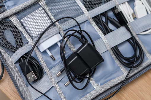 USB cables and chargers arranged in an organizer with compartments closeup