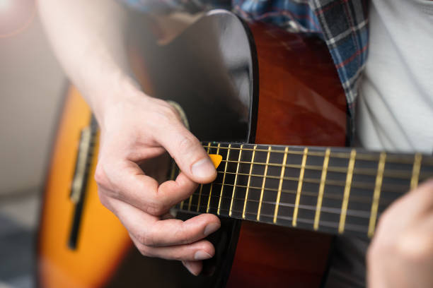 istock A young man with mediator playing guitar. Close-up. Selective focus. 1770256861
