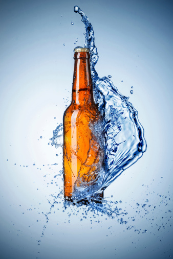 Bottle of beer with water splash on blue backgroundClick and find more: