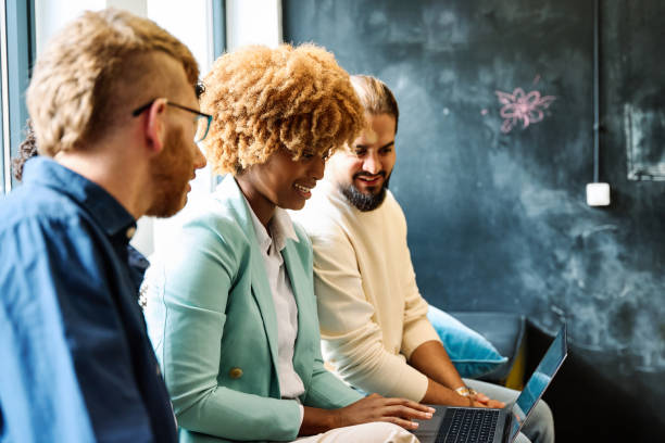 istock Multi-ethnic coworkers using laptop together sitting on a comfortable sofa 1770276010