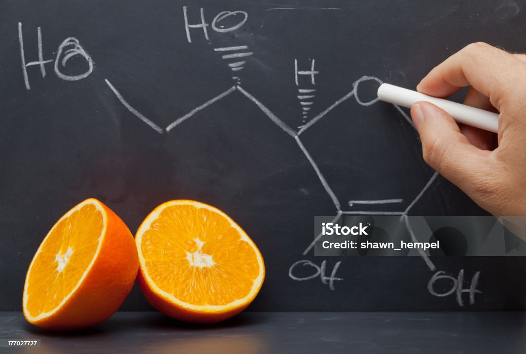 Vitamin C structure Hand drawing structural formula of vitamin C on blackboard with oranges in front Chemical Formula Stock Photo