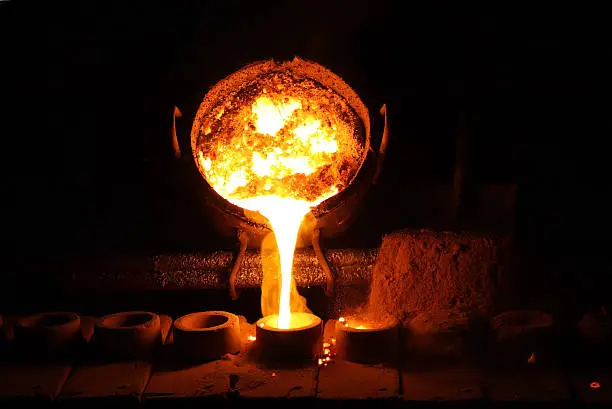 Foundry - molten metal poured from ladle for casting