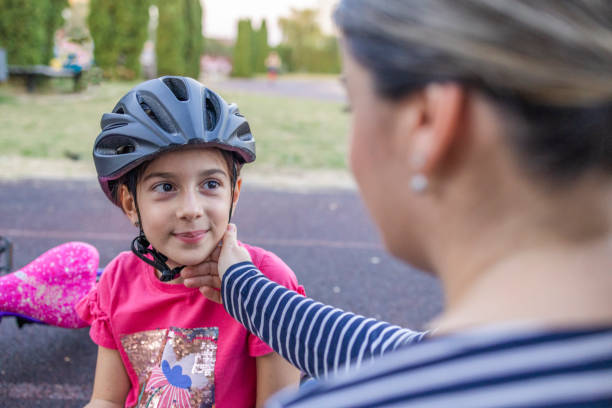 istock Mom strokes her daughter's cheek after successfully riding a bicycle 1770287678