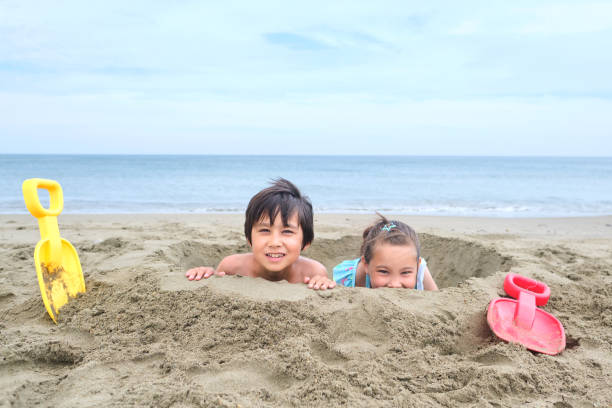 istock Children dig a hole in the sand on the seashore. 1770292809