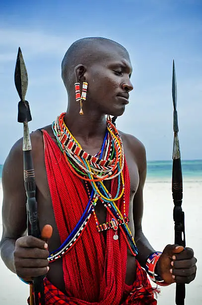 Maasai sitting by the ocean on the beach