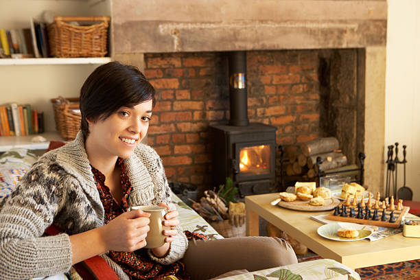 istock Young woman having tea by fire 177029973