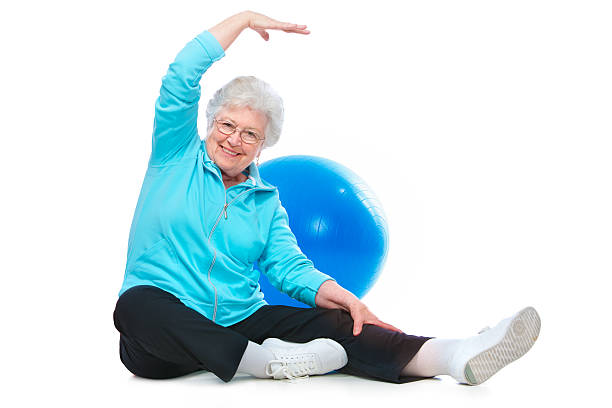 пожилая женщина делает растяжения упражнения - grandmother action senior adult grandparent стоковые фото и изображения