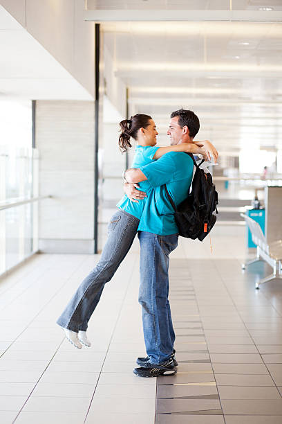 istock young couple hugging at airport 177030560