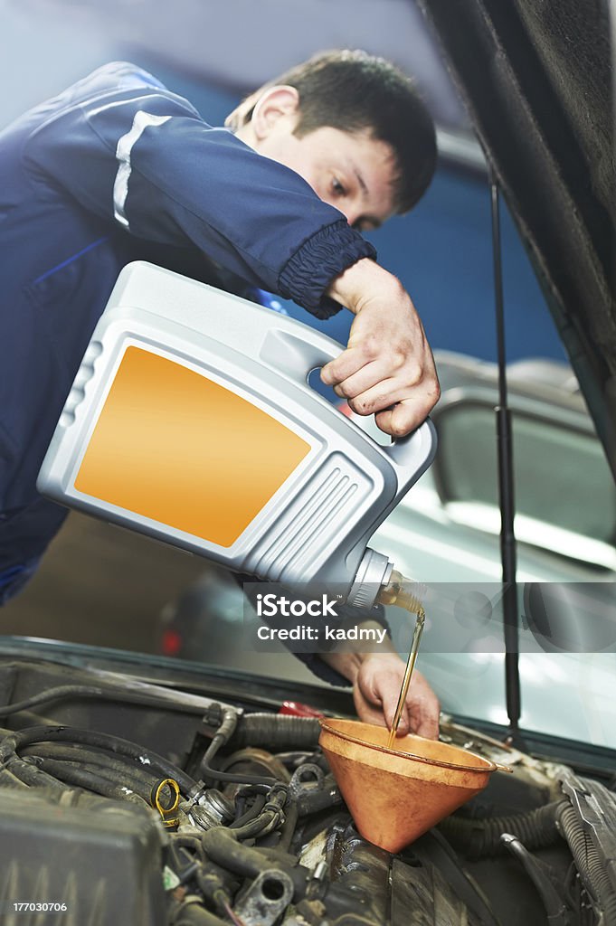 Samochód Mechanik nalewać olej do napędu silnika - Zbiór zdjęć royalty-free (Benzyna)
