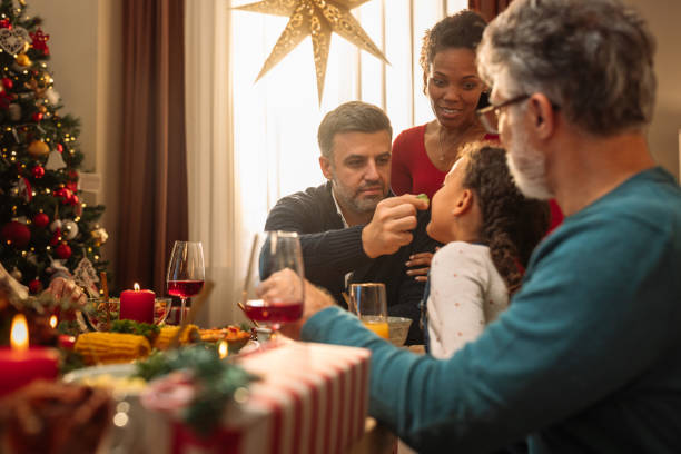 father feeding his little daughter during a christmas feast - drinking little girls women wine imagens e fotografias de stock