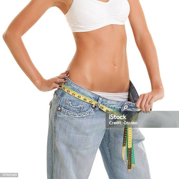 Woman Shows Her Weight Loss By Wearing An Old Jeans Stock Photo - Download Image Now