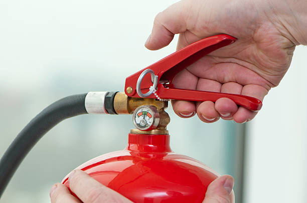 hand presses die automatische meldung feuerlöscher - feuerwache grafiken stock-fotos und bilder