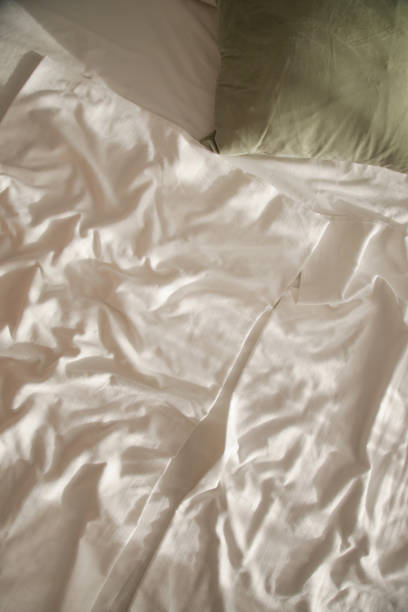 istock Messy bed. White cotton unmad blanket and sheets on bed. 1770313689