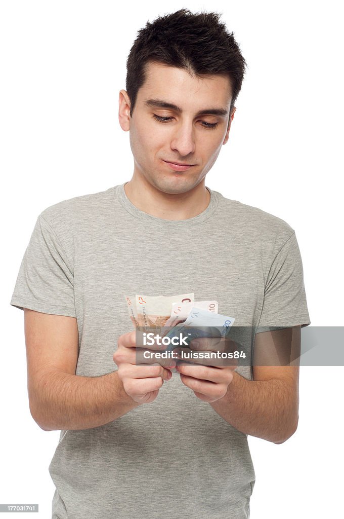 Man holding money "quiet young man looking at his money, euro bills (isolated on white background)" Adult Stock Photo