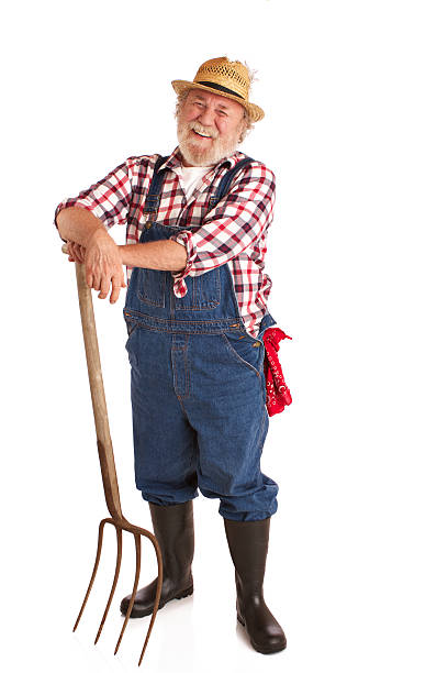 Cheerful senior farmer leaning on pitchfork