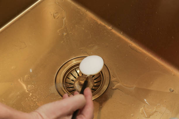 istock Cleaning kitchen sink with bakIng soda to keep sinks draining well and prevent clogs. Safe, effective, cheap, natural solution for clogged drains. 1770327627