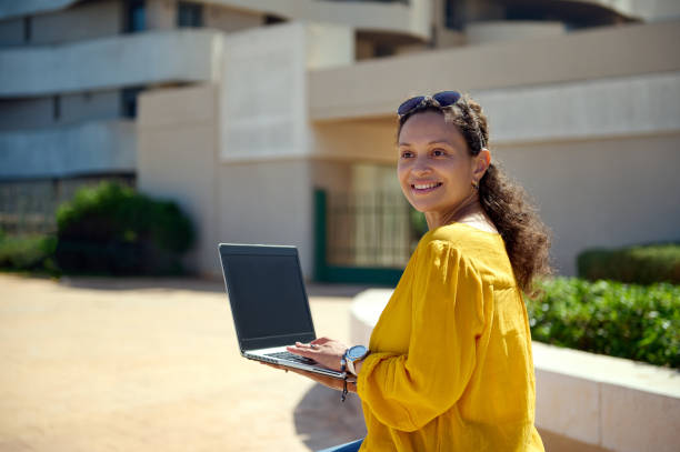 istock Smiling middle aged confident business woman using a laptop with black blank mockup screen. Copy space for mobile app 1770329696