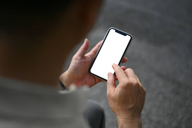 istock Over shoulder view of middle age man using mobile phone at outdoor. White screen for your text message 1770332861