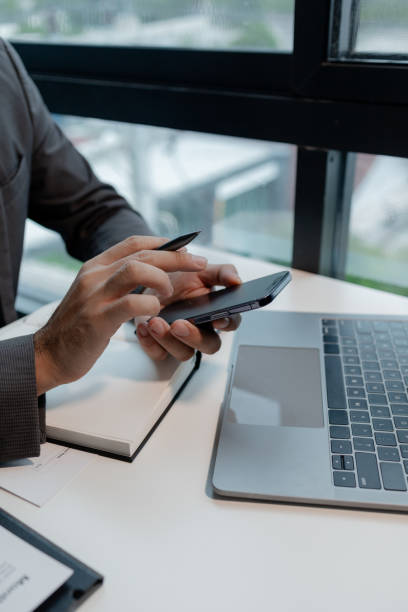 istock he is using his phone to find information to use in presenting information, Entrepreneurs use smartphones to keep in touch with business partners while working in the company, startup idea. 1770341171