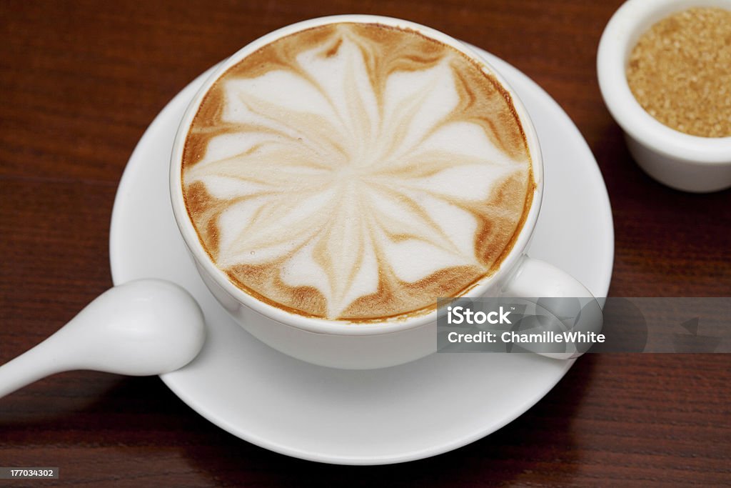 Capuchino, una taza de café y caña de azúcar - Foto de stock de Adorno de espuma libre de derechos