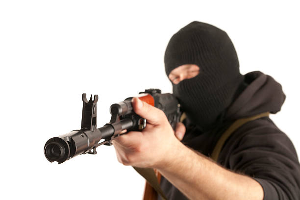 Man in mask with gun Man in mask with gun on white background firing squad stock pictures, royalty-free photos & images