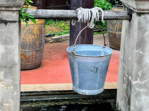 istock a bucket hanging from a wooden rail. 1770346110