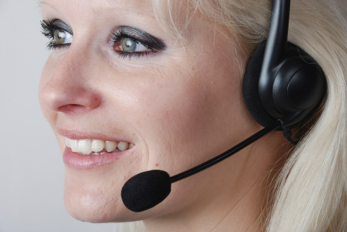 customer representative with headset smiling during a telephone conversation