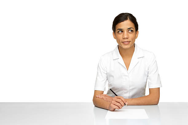 Woman wearing a white lab with pencil and paper stock photo