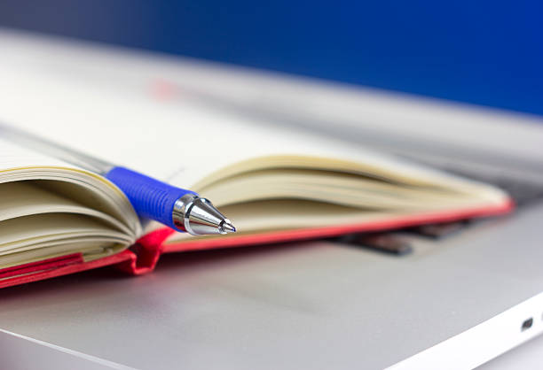 notebook auf dem laptop, flachen fokus - macro book laptop office stock-fotos und bilder