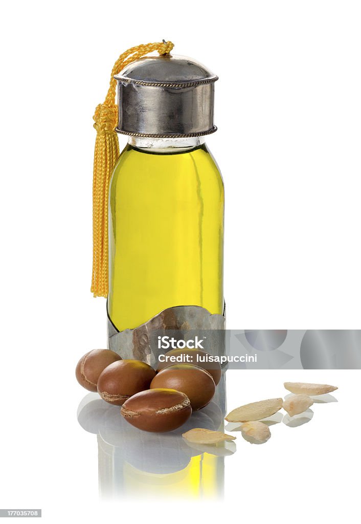 Vetro bottiglia di olio di argan con dadi e semi - Foto stock royalty-free di Albero di argan