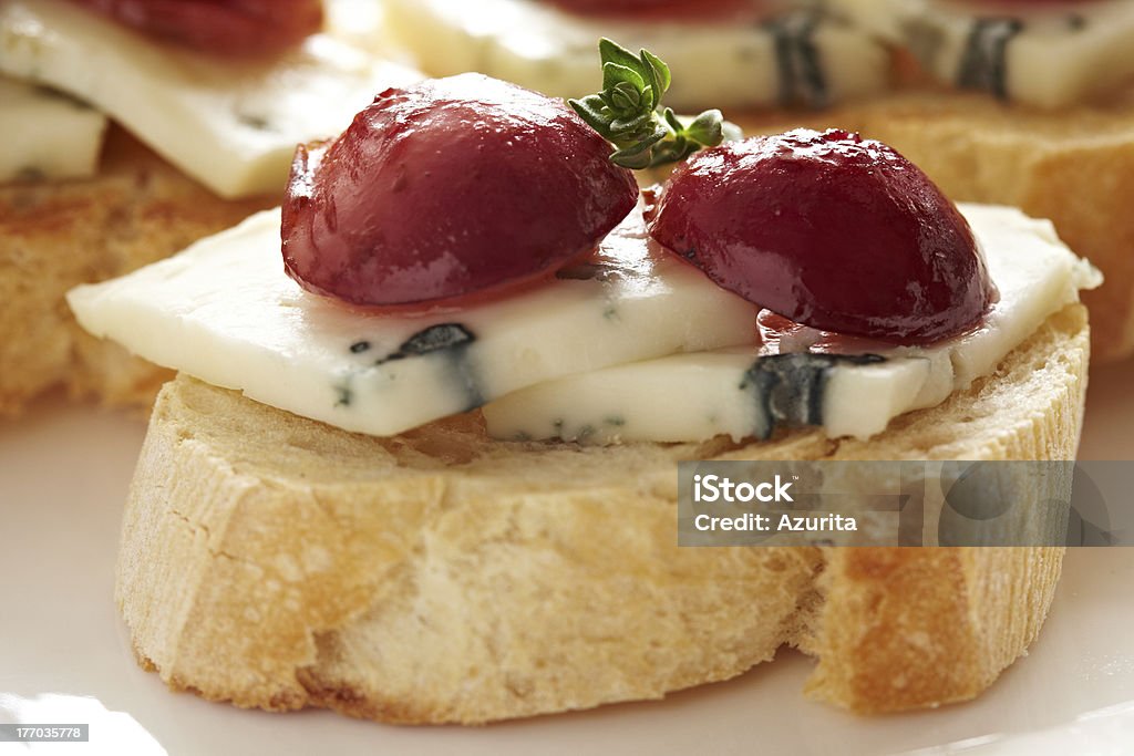 Crostini with Gorgonzola, Roasted Grapes and Thyme "Crostini Topped with Gorgonzola Blue Cheese, Roasted Red Grapes and Thyme" Antipasto Stock Photo