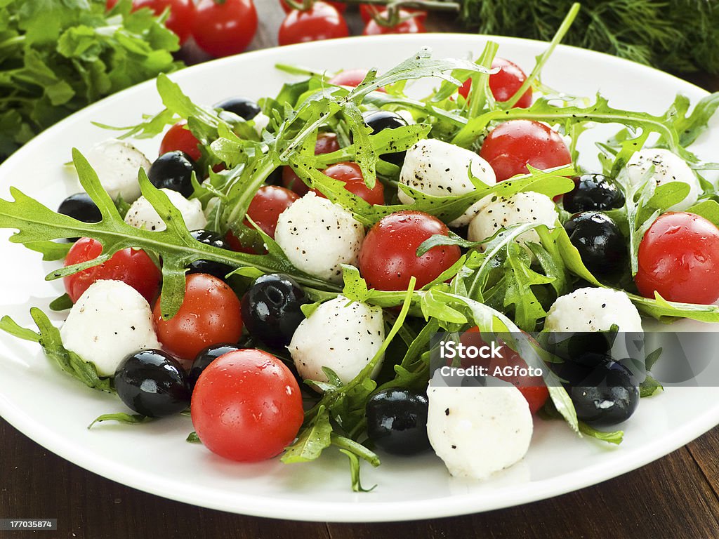 Salad "Fresh salad with cherry tomatoes, rucola, mozzarella and black olives. Shallow dof." Appetizer Stock Photo