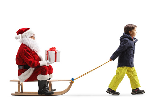 Ssanta holding a present and sitting on a sled pulled by a child isolated on white background