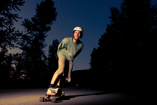 Young man riding longboard in canadian wilderness