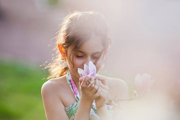 istock young girl smells at a blossom 177036232