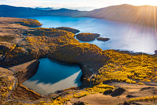 POV: Aerial view, Big blue lake and islands in volcanic crater mountain and green forest around it at sunset. volcanic, crater, lake, island, aerial, drone, sunset, senrise nemrut dagi stock pictures, royalty-free photos & images