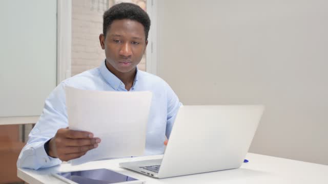 African Businessman Reading Documents at Work