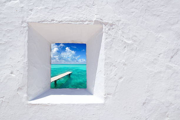 istock White wall window with glimpse of Ibiza's turqoise waters 177036575