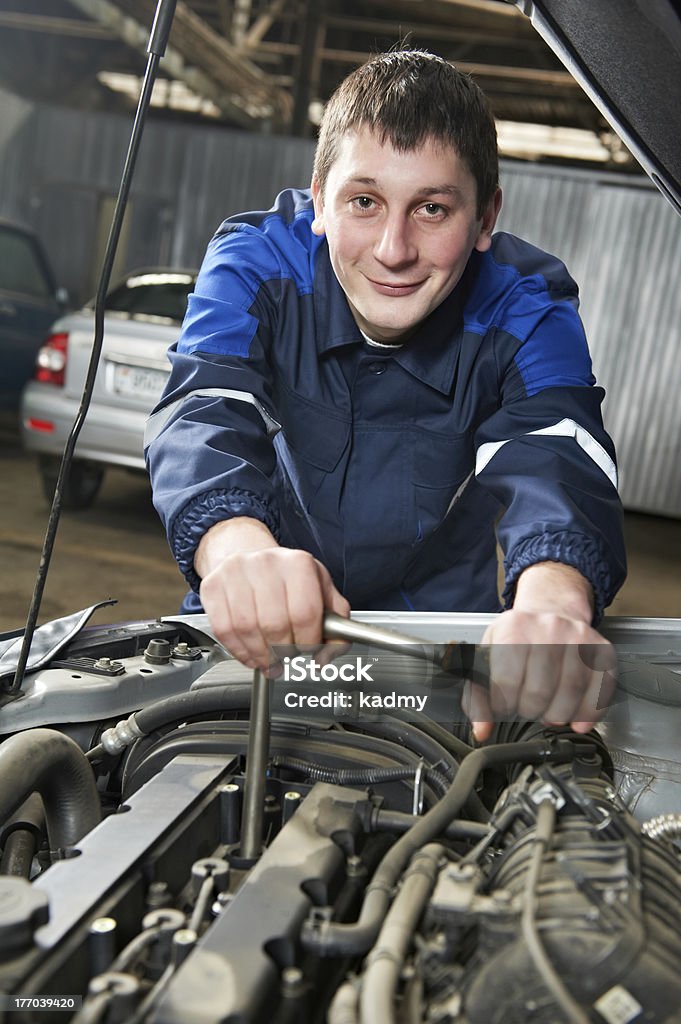 Felice automotive meccanico al lavoro con una chiave - Foto stock royalty-free di Fallimento