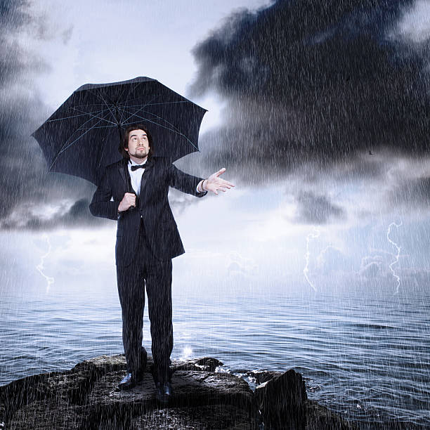 istock Man Under Umbrella Checking for Rain Coming or Clearing 177039522
